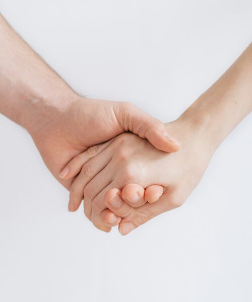Zwei Hände halten sich gegenseitig als Symbol für Vertrauen und Unterstützung.